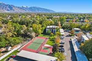 Aerial view of tennis and basketball courts featuring a mountain backdrop