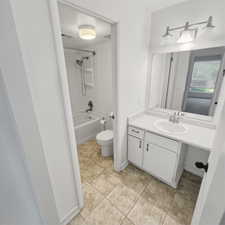 Full bath featuring vanity,  shower combination, and light tile patterned floors