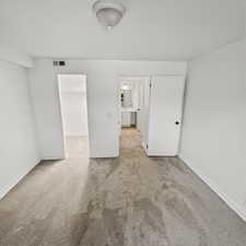 Final angle of bedroom featuring a spacious closet, light colored carpet, and ensuite bathroom