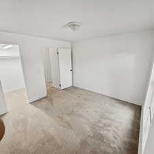 Another angle of bedroom with a spacious closet and light colored carpet