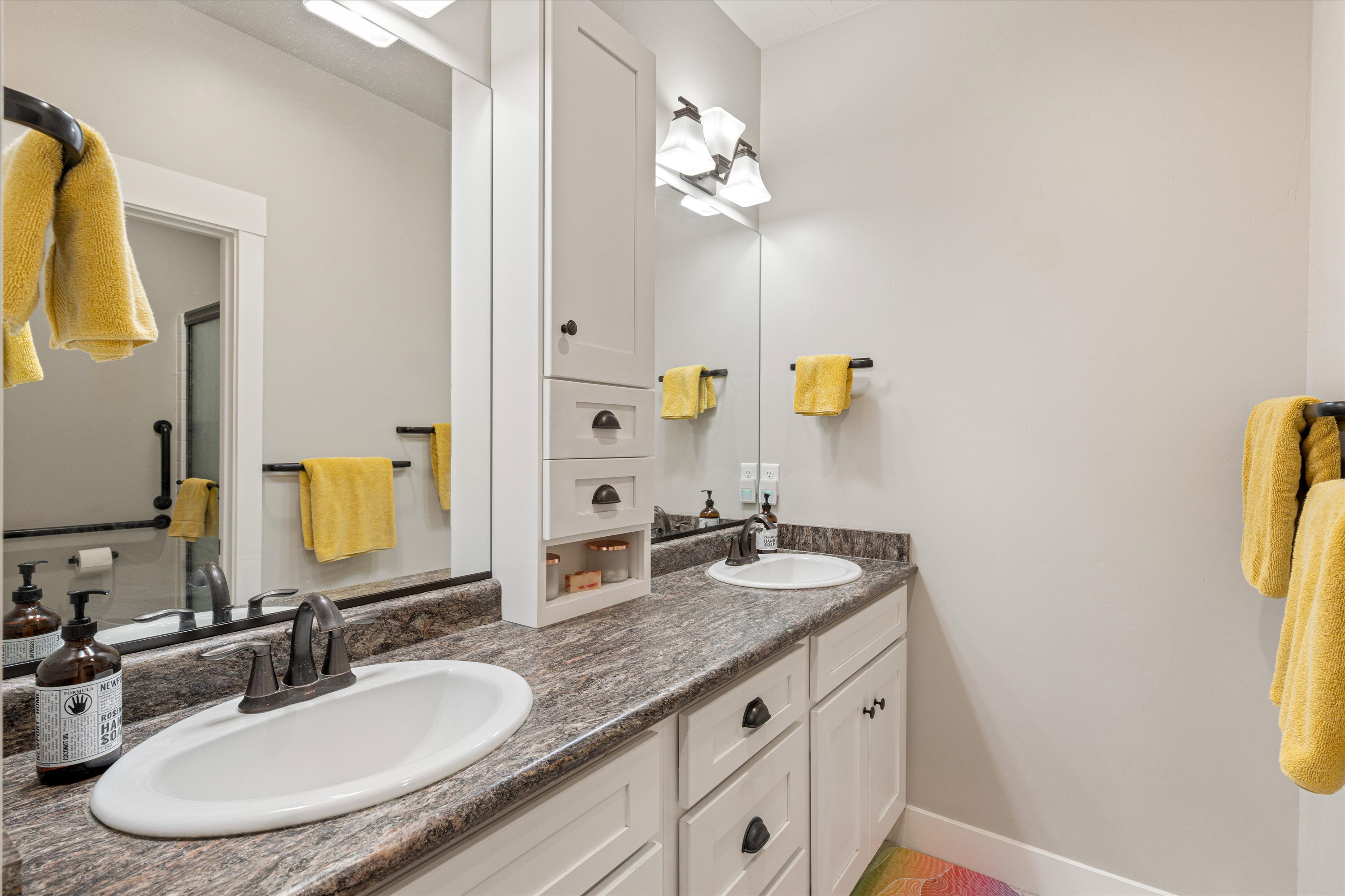 Full bathroom with double vanity and baseboards