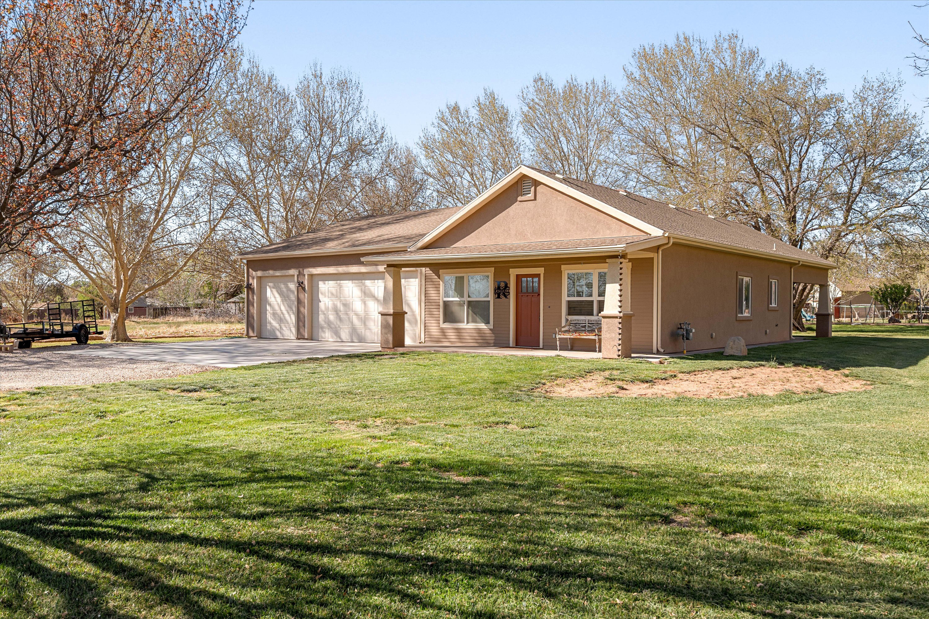 View of front of house featuring driveway, a porch, a garage, a front lawn, and a shingled roof