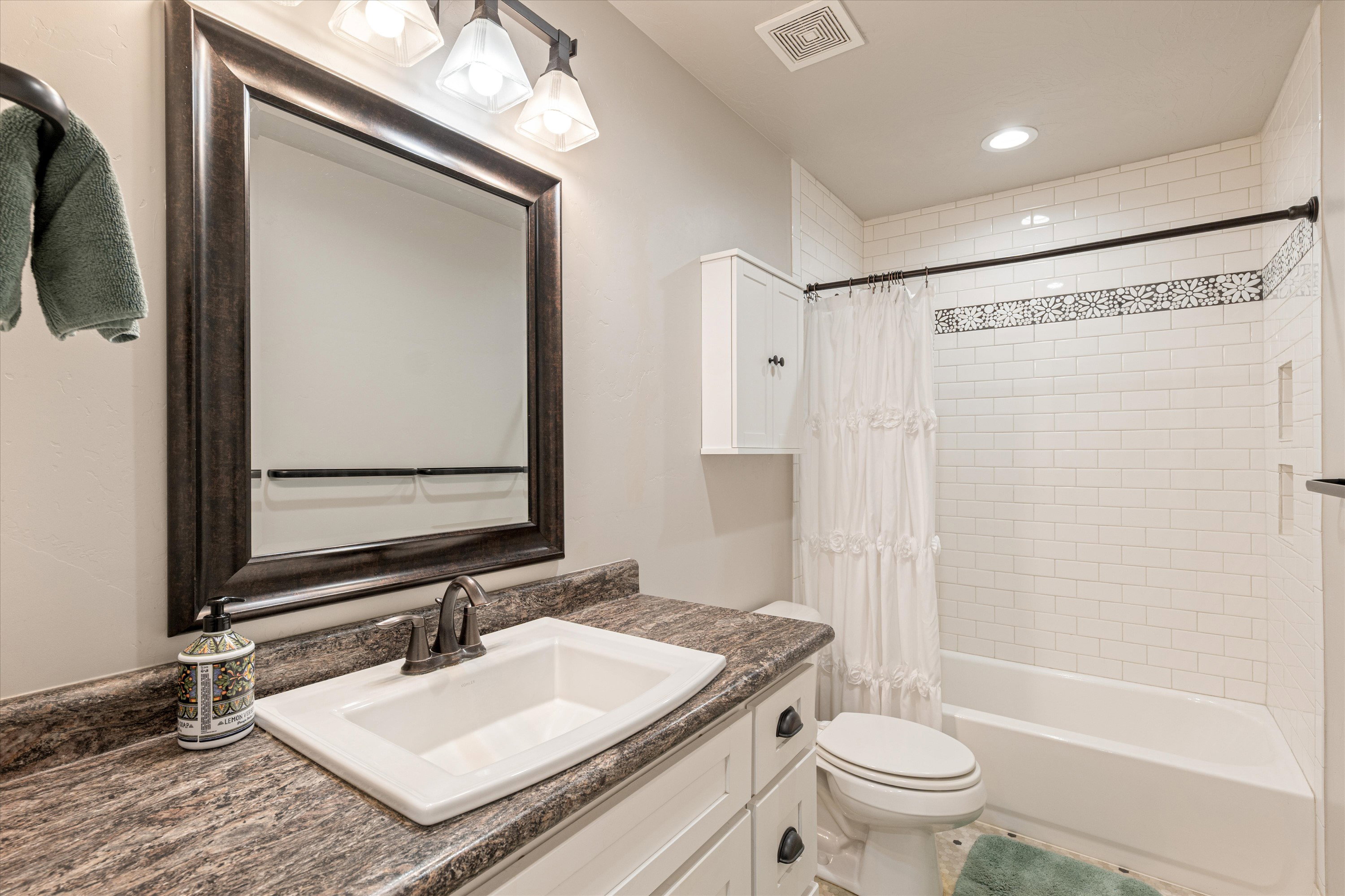 Full bath with vanity, shower / bath combo with shower curtain, and recessed lighting