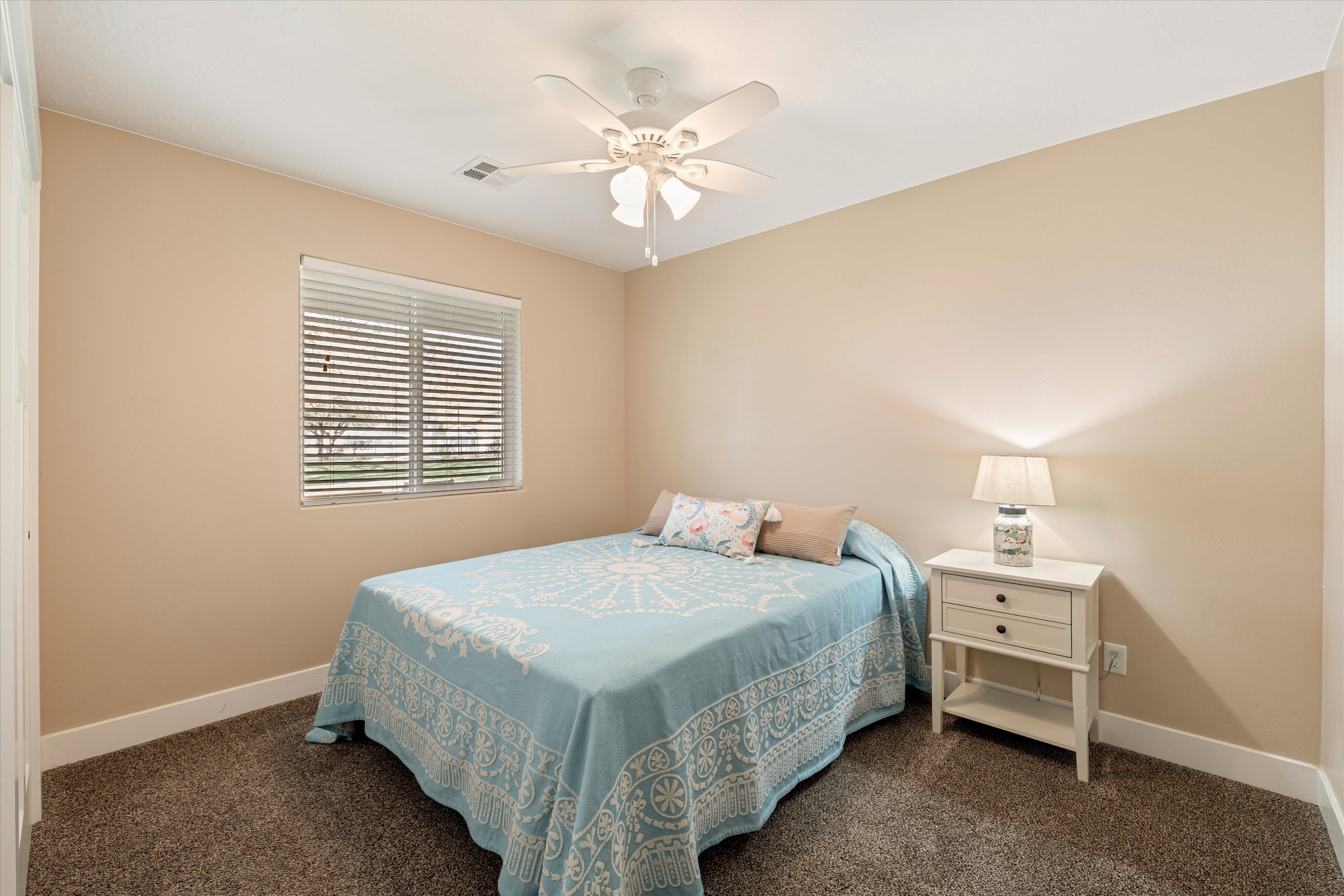 Bedroom with a ceiling fan and dark colored carpet