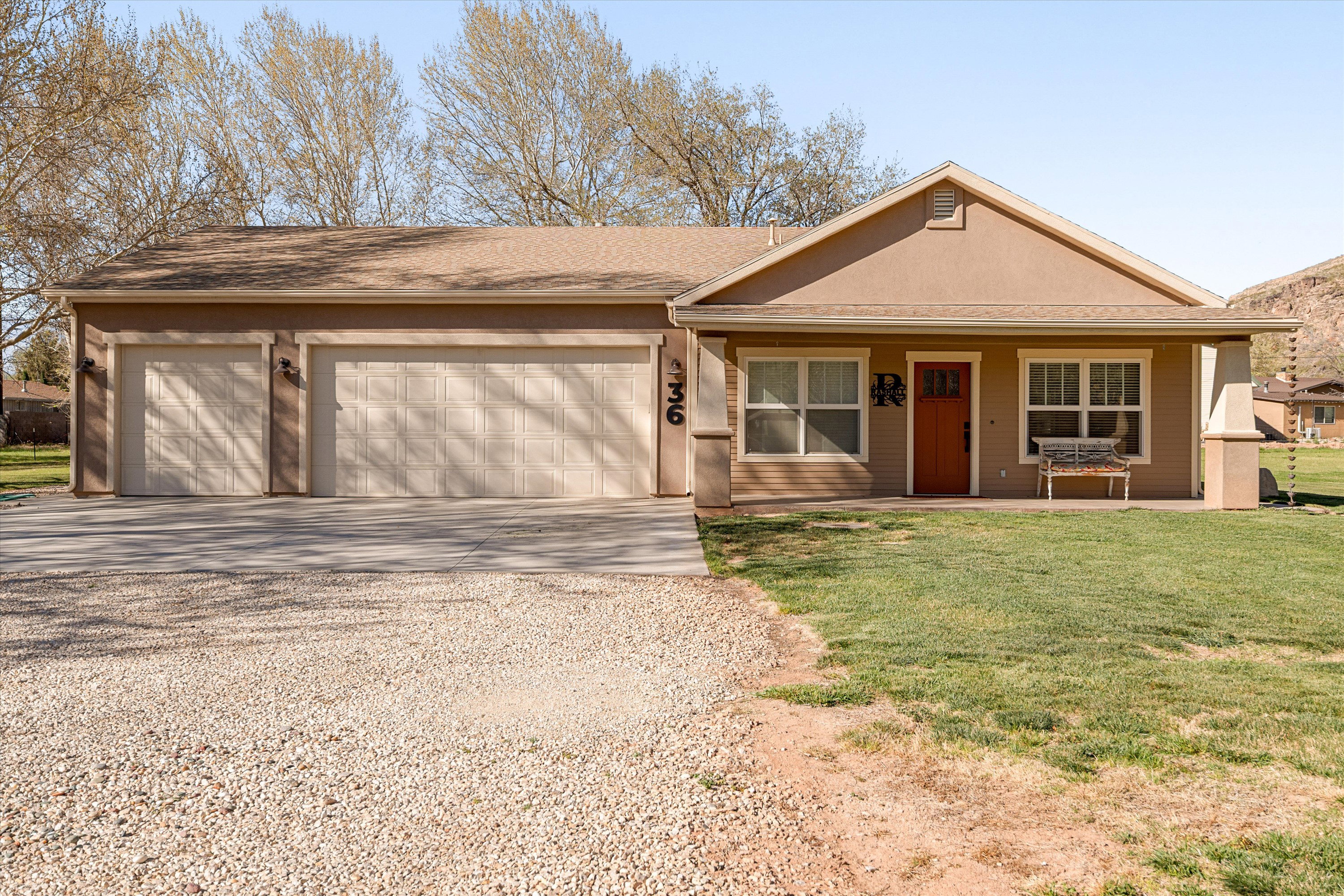 View of front of property featuring driveway, covered porch, a garage, a front lawn, and a shingled roof