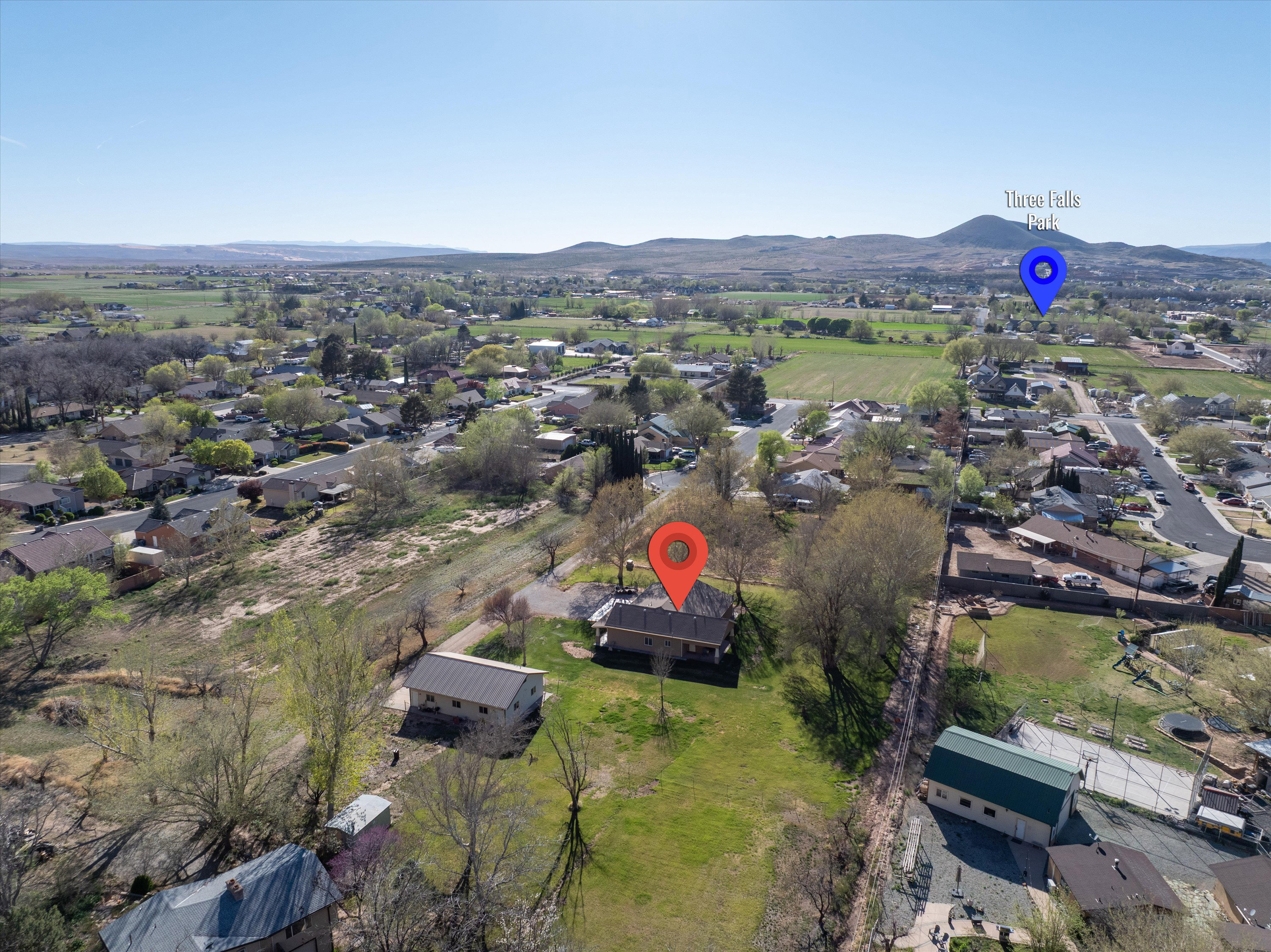 Aerial view of property and surrounding area with nearby suburban area and mountains