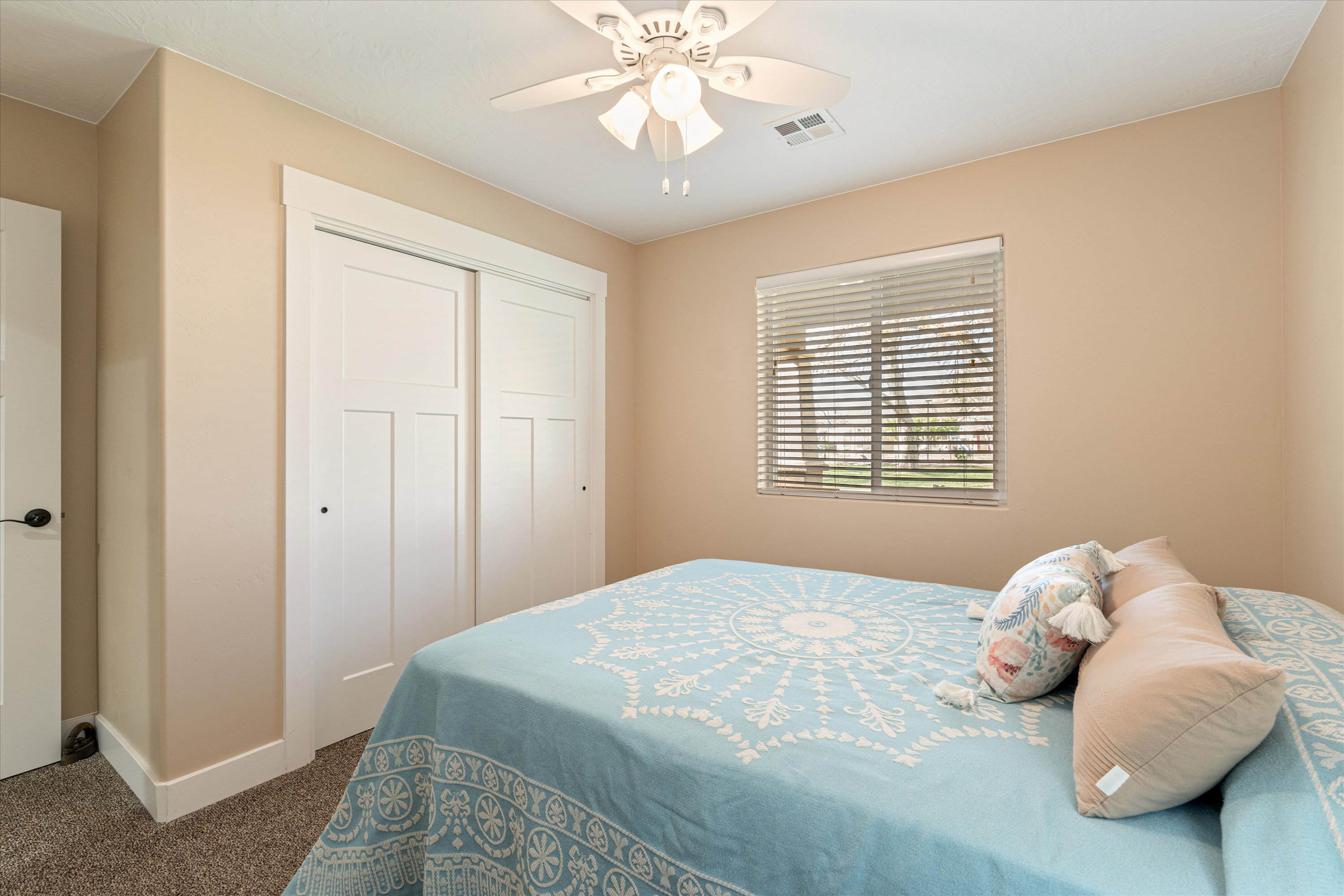 Bedroom with dark carpet, a ceiling fan, and a closet