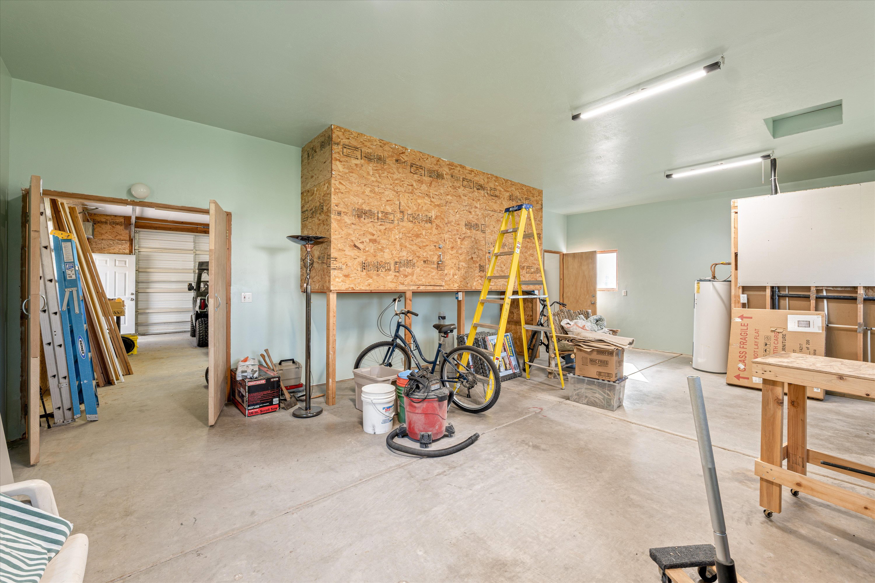 Misc room featuring concrete flooring and water heater