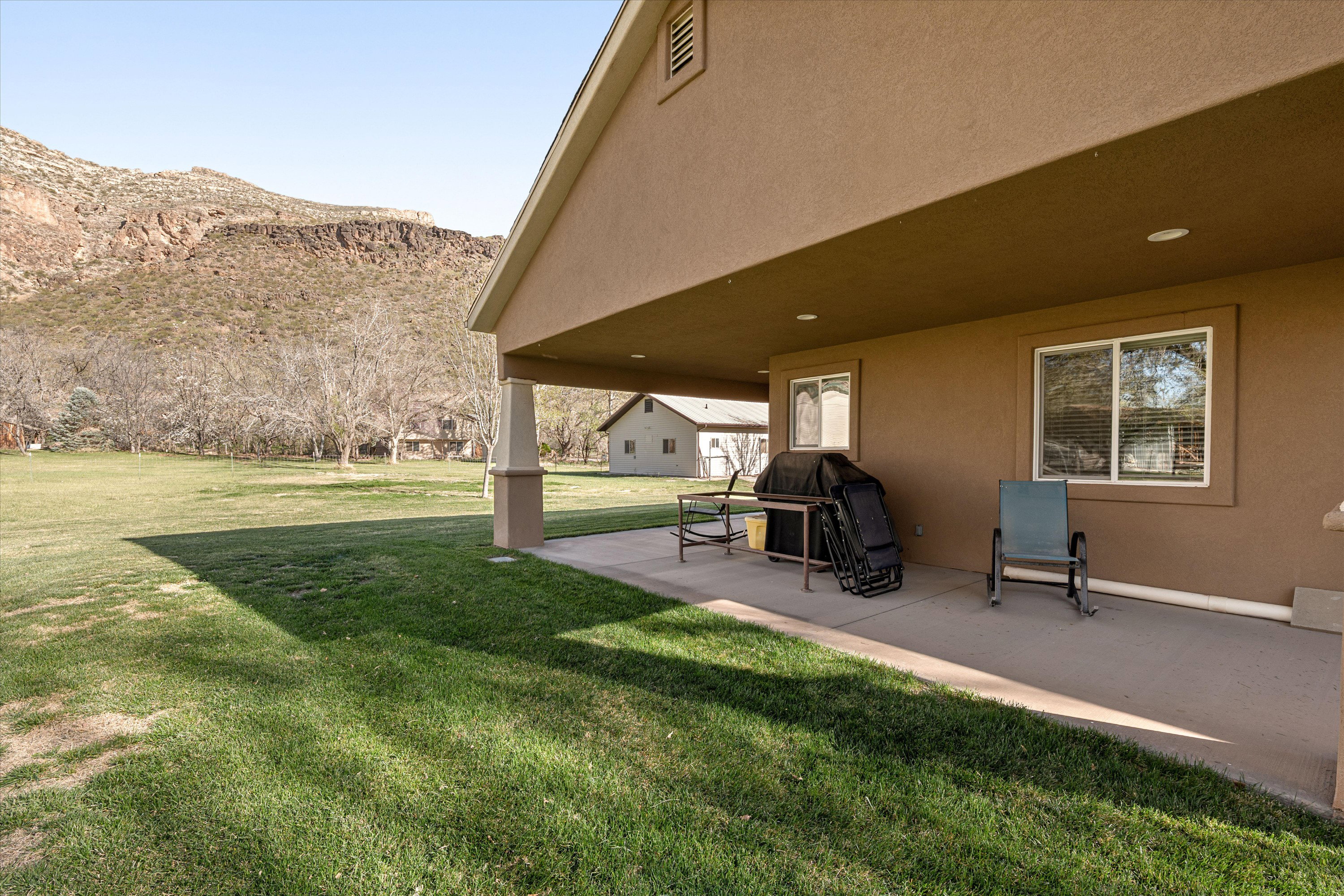 View of grassy yard with a mountain view and a patio area