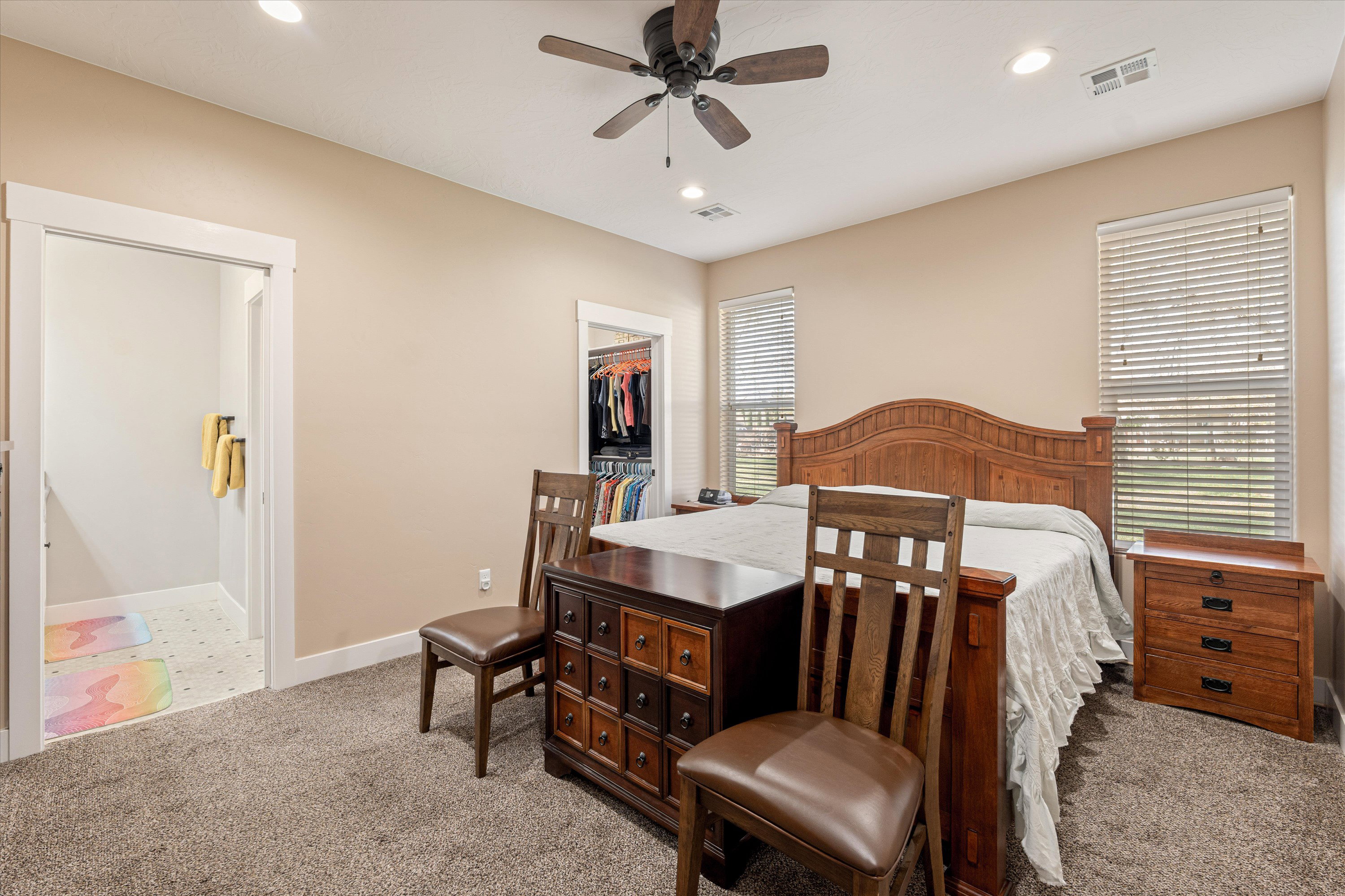 Carpeted bedroom with a walk in closet, recessed lighting, and ceiling fan