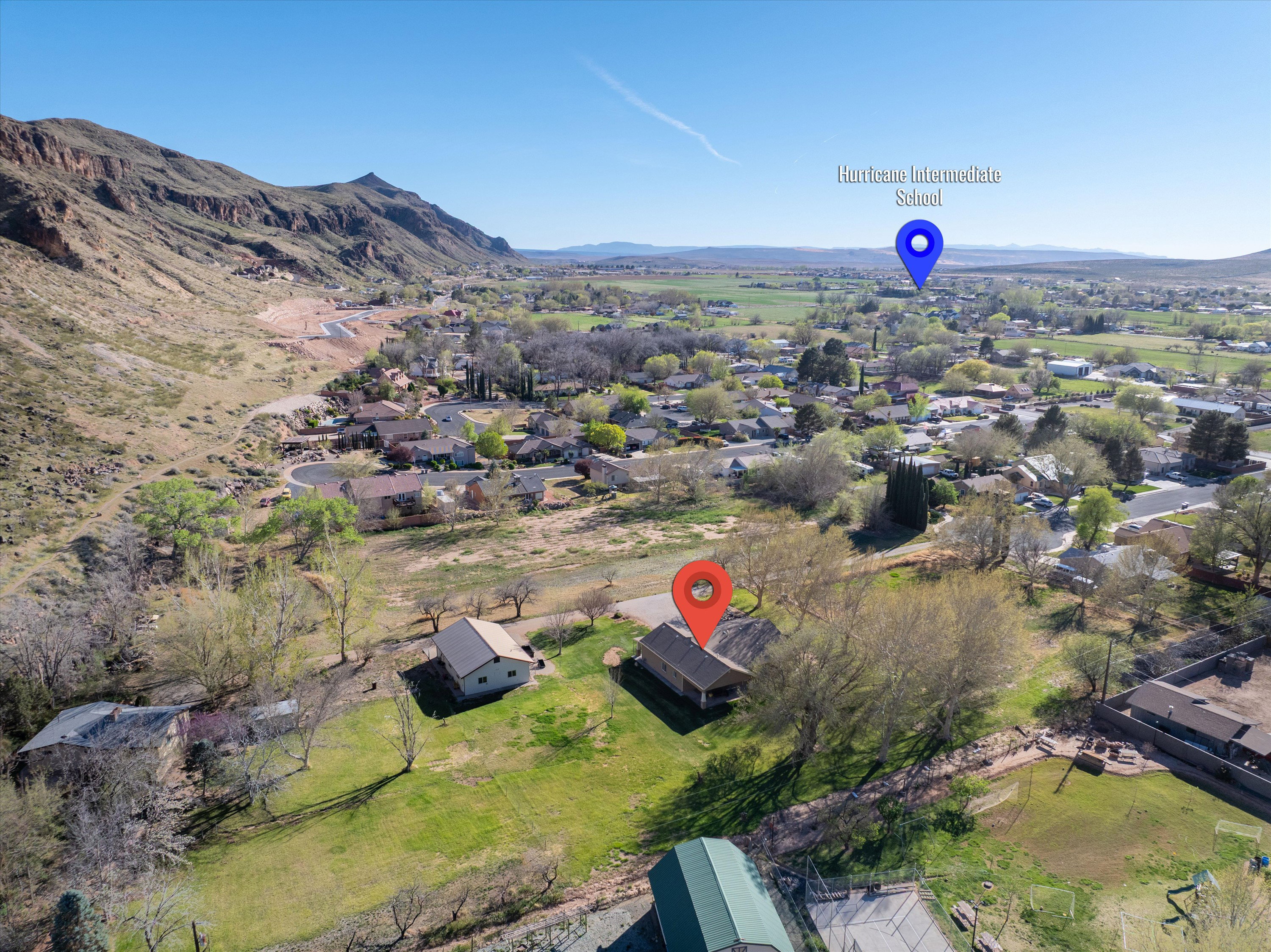 Aerial view of property and surrounding area with mountains and nearby suburban area