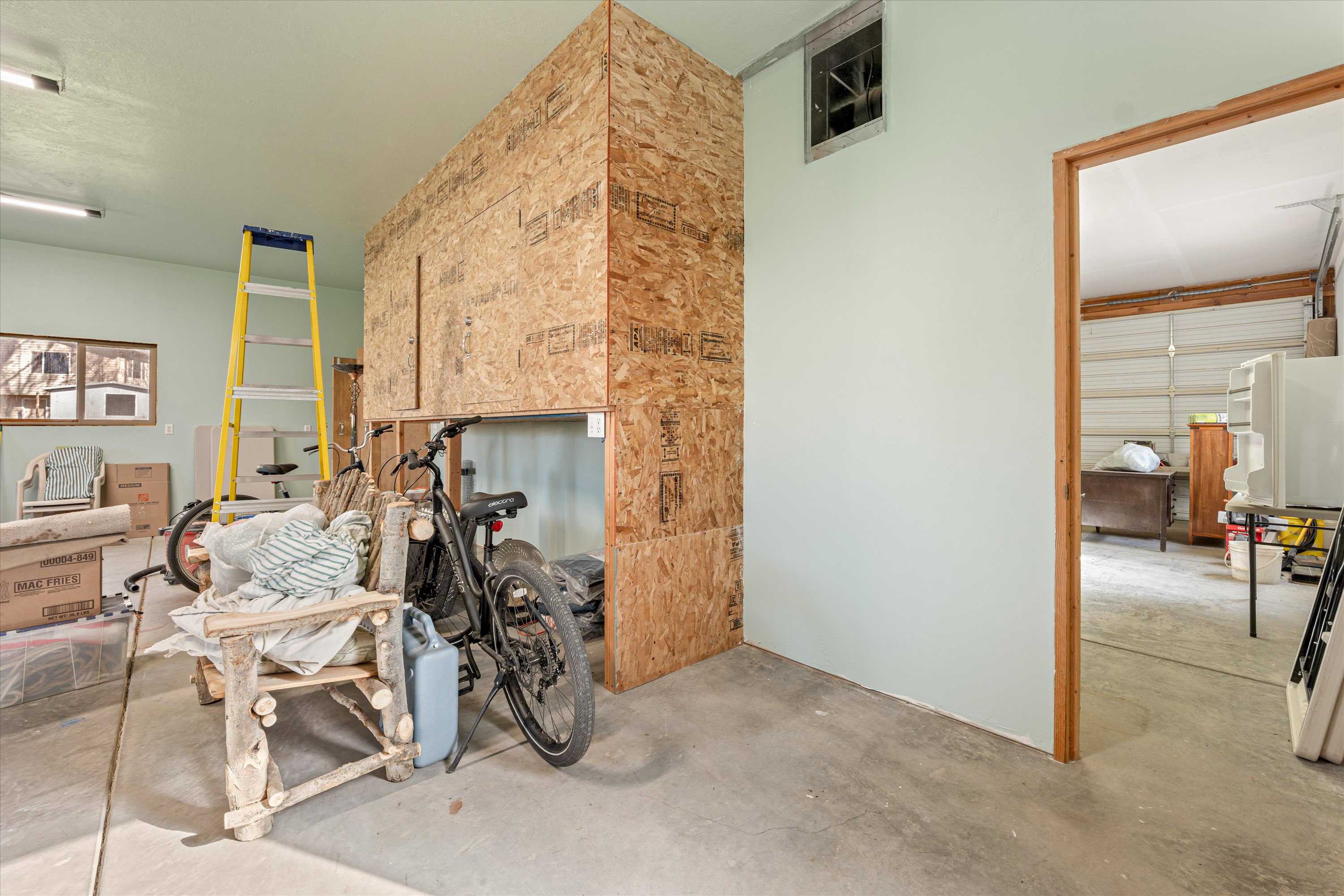 Miscellaneous room featuring unfinished concrete floors and a garage