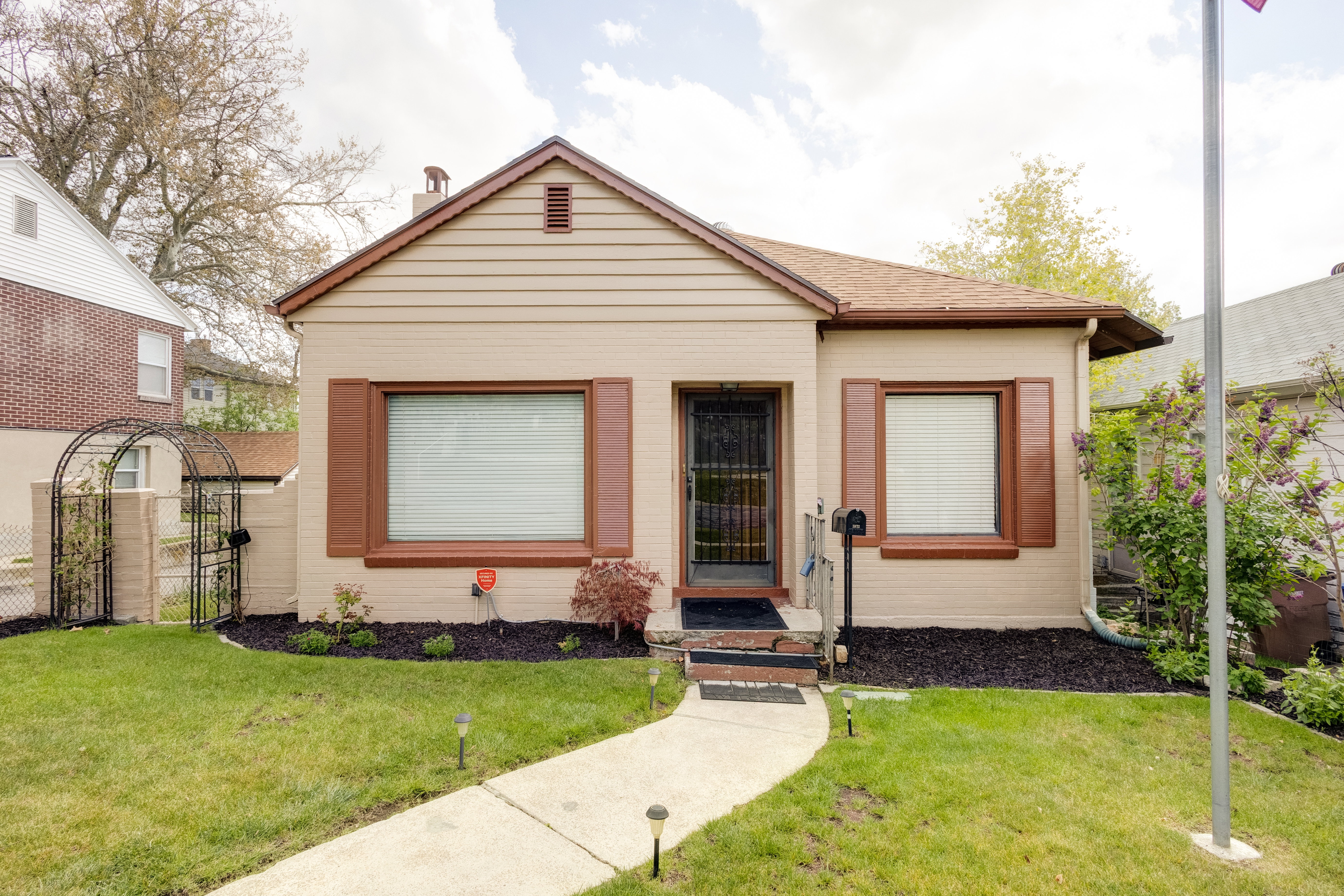 View of front of property with a gate and a shingled roof