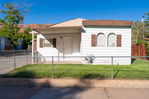 View of front of property featuring covered porch and a fenced front yard