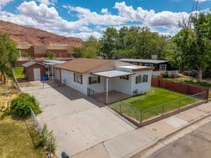 View of front of house featuring driveway, a storage unit, a mountain view, and a metal roof