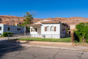View of front of property with a fenced front yard and a mountain view