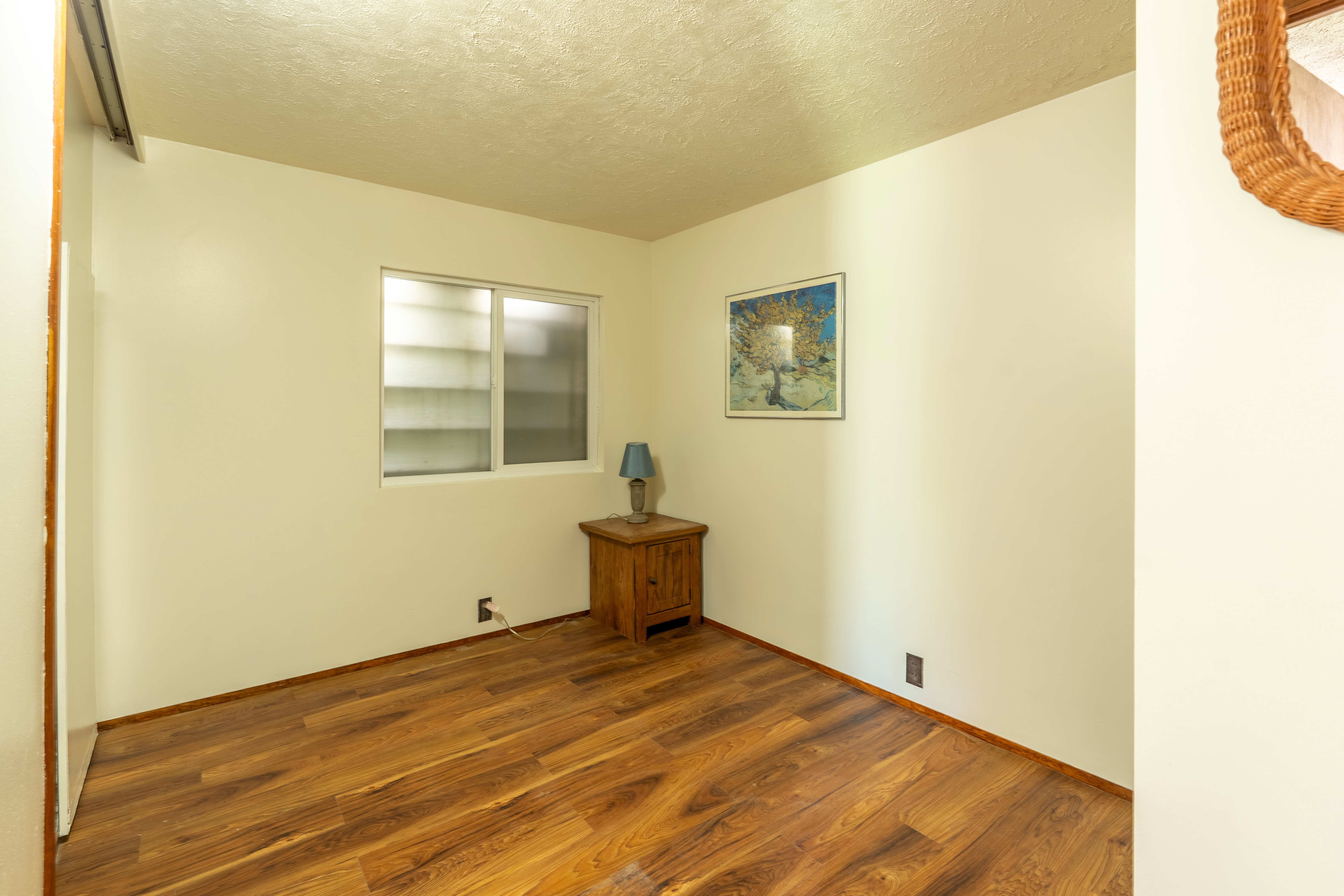 Empty room featuring a textured ceiling and wood finished floors