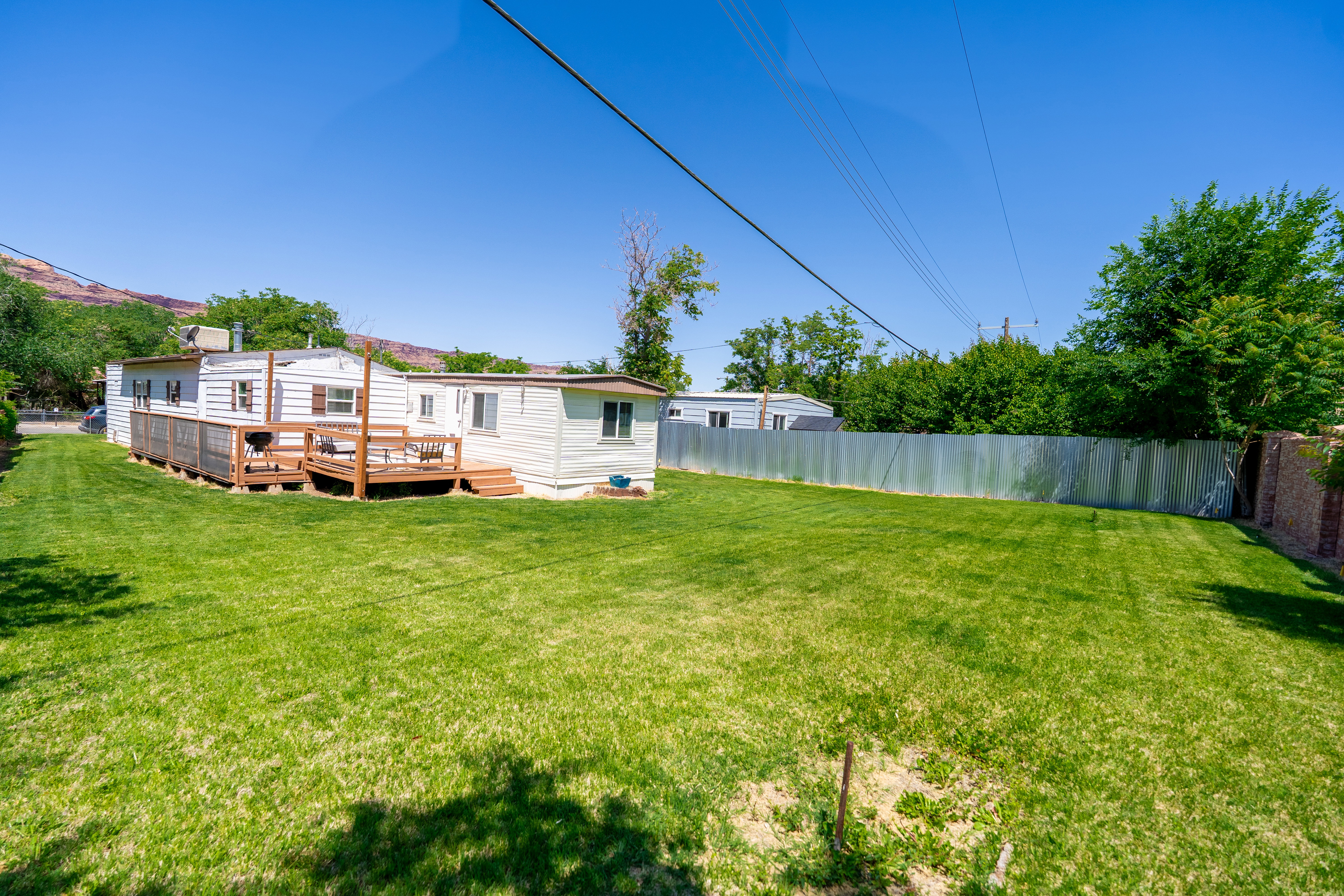Rear view of house with a wooden deck and a fenced backyard