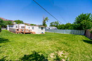 Rear view of house with a wooden deck and a fenced backyard