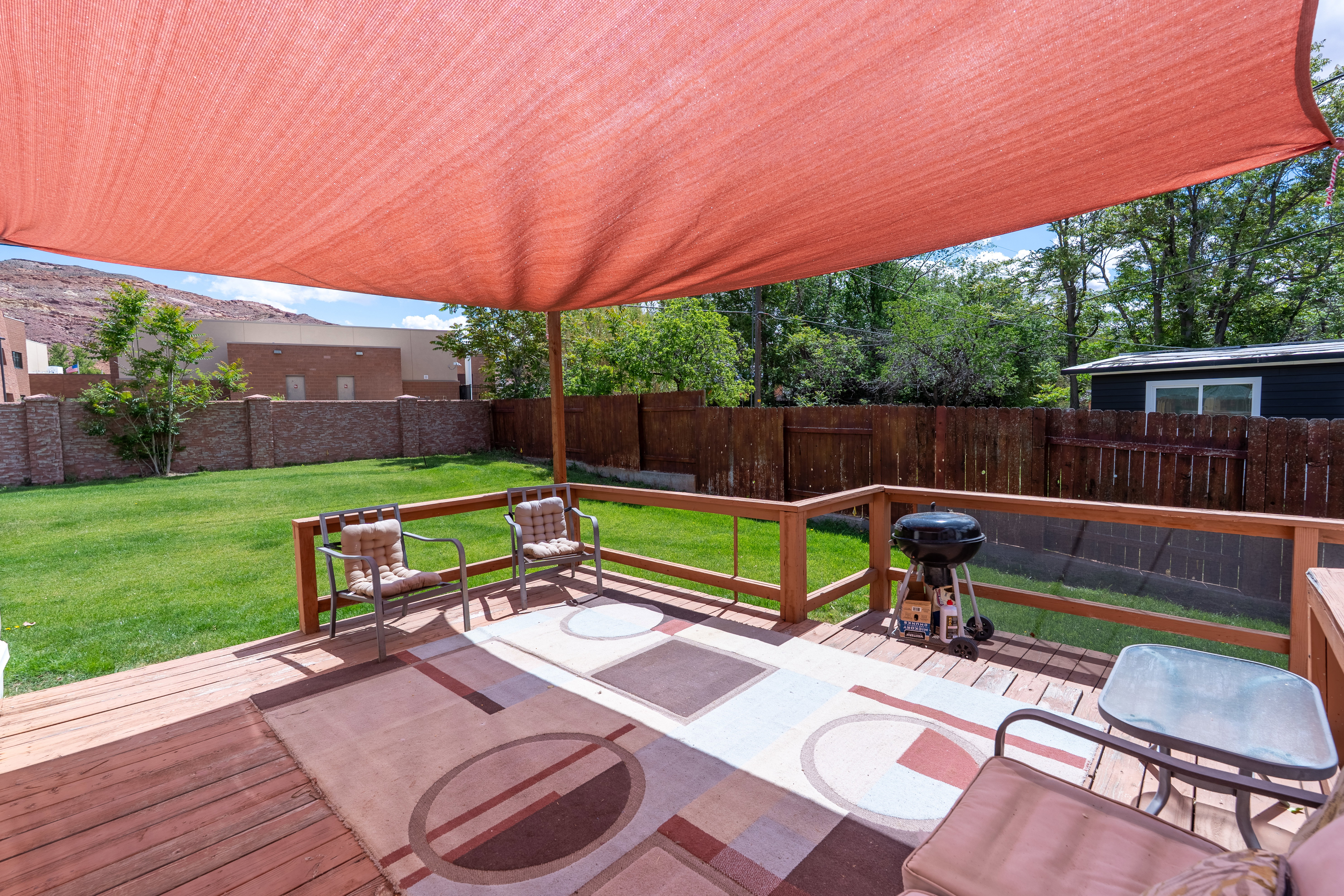 Fenced backyard with grilling area and a deck