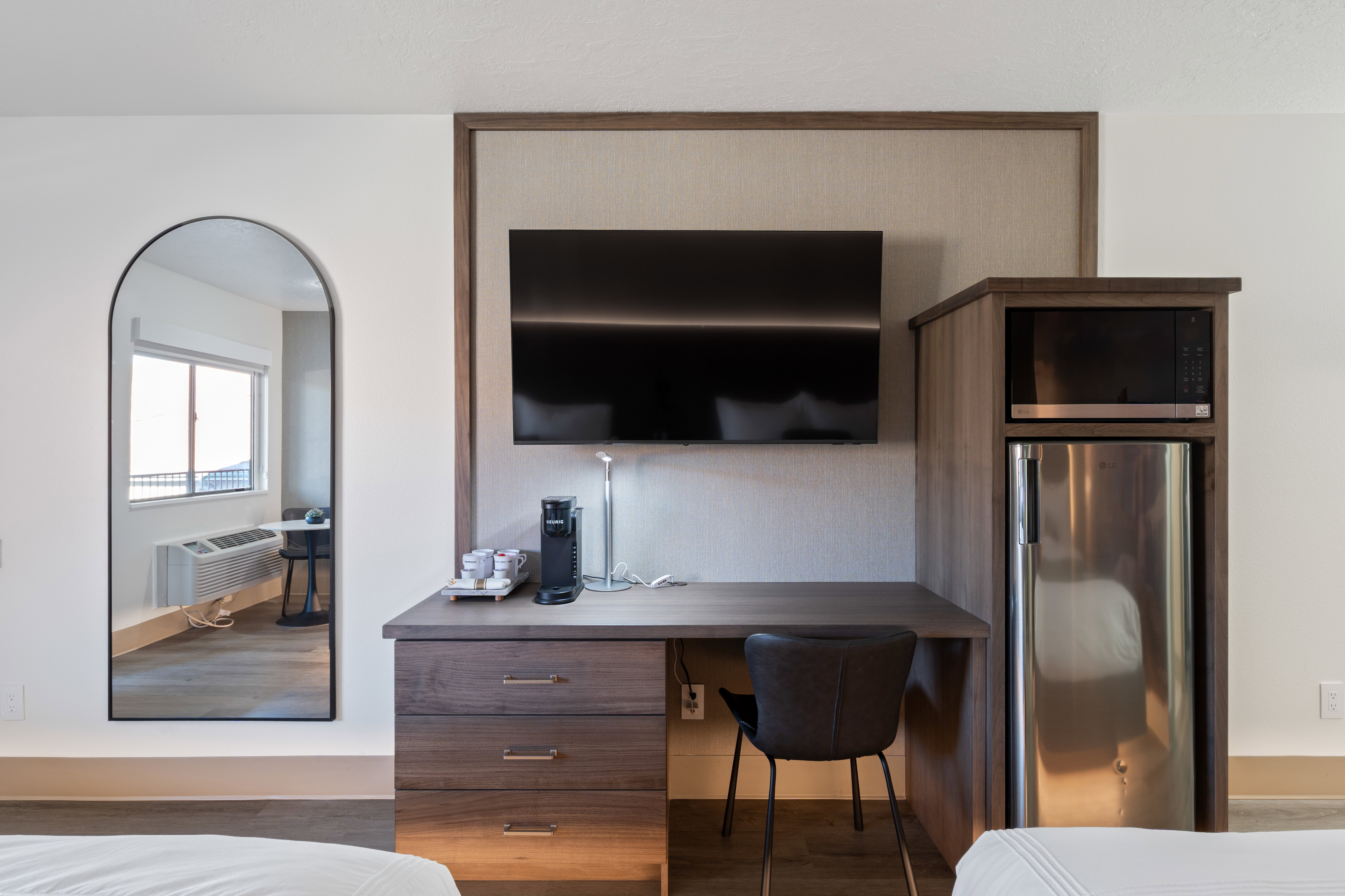 Bedroom with freestanding refrigerator, built in study area, and wood finished floors