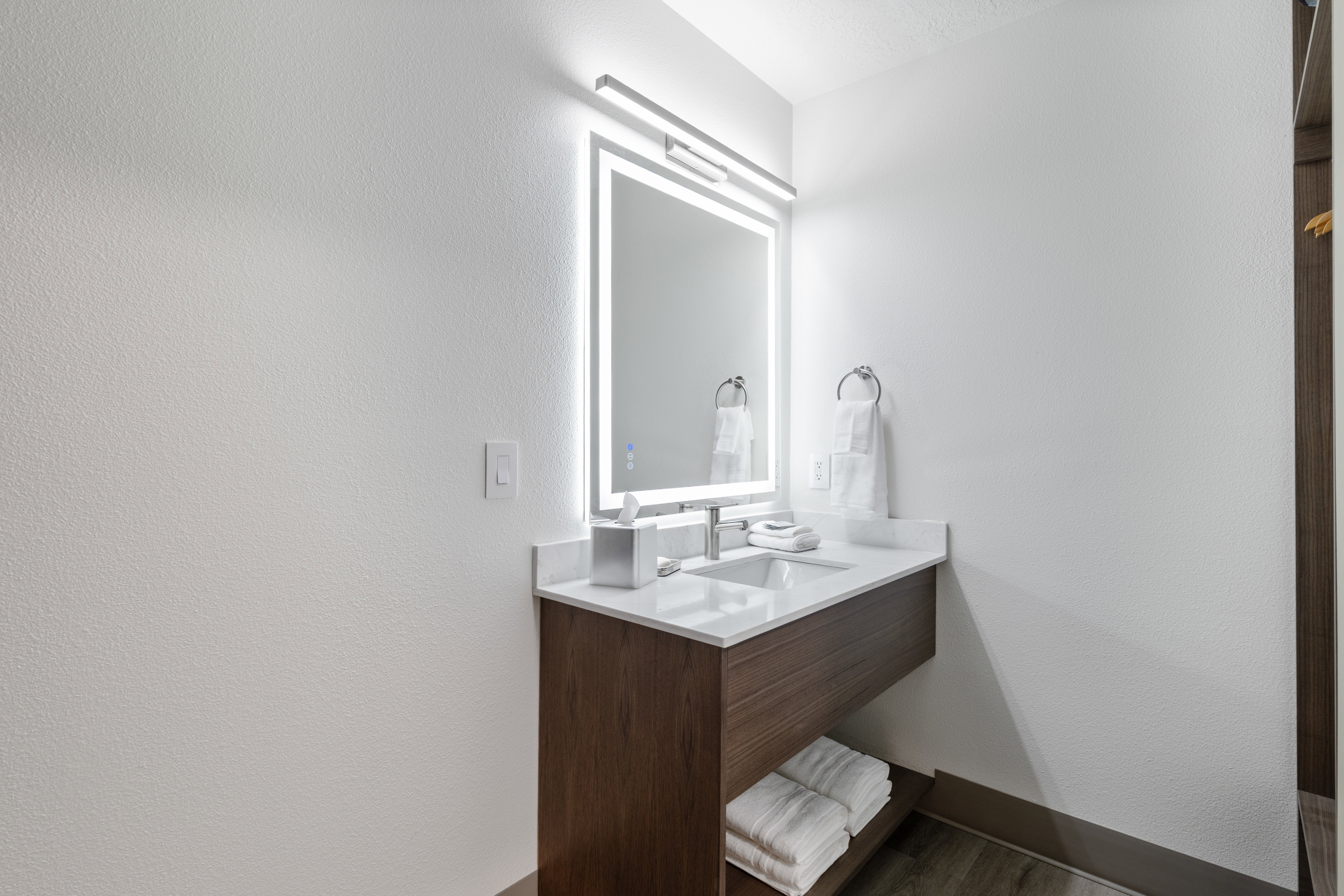 Bathroom with vanity, a textured wall, and wood finished floors