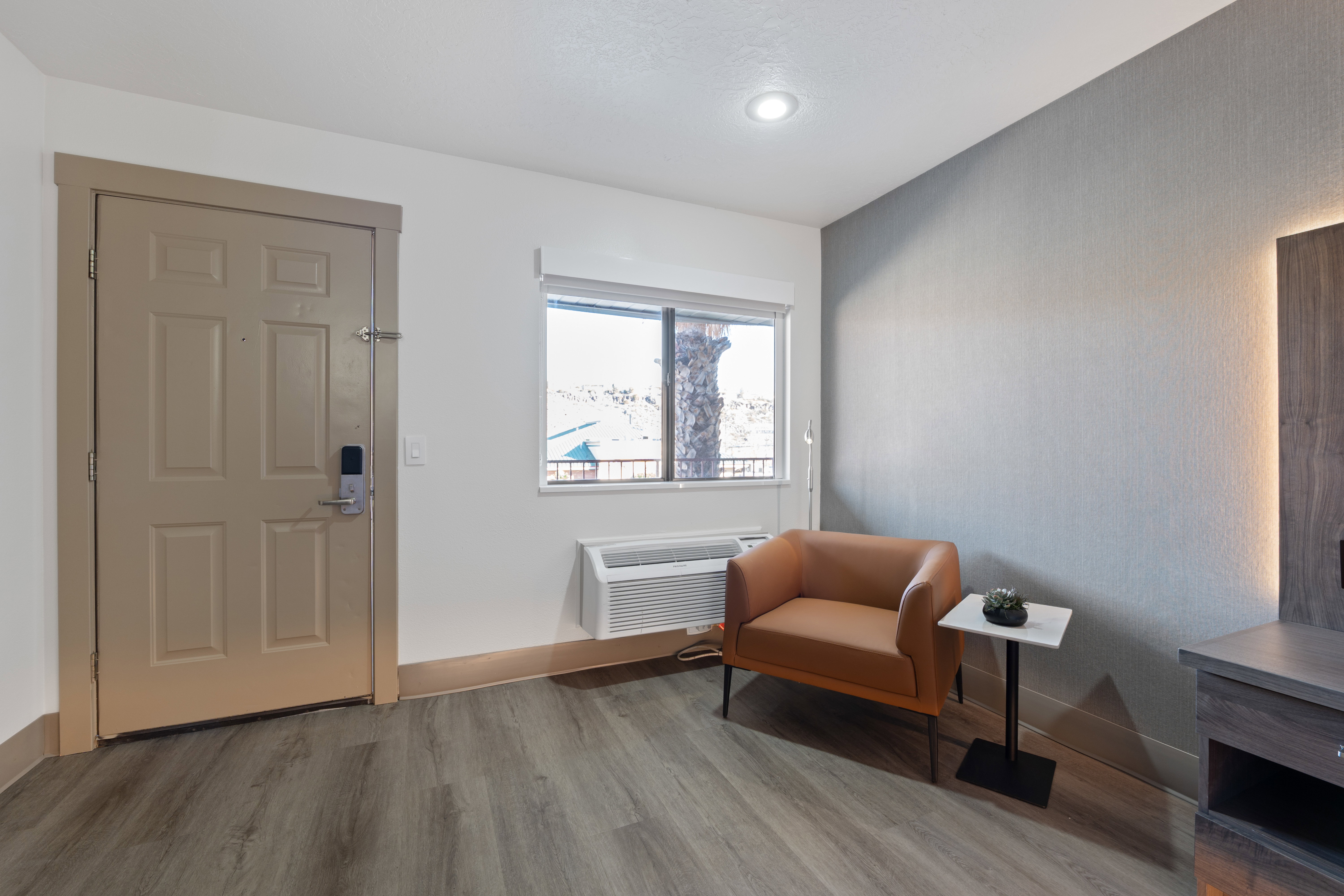 Living area with light wood-style flooring and a ptac unit