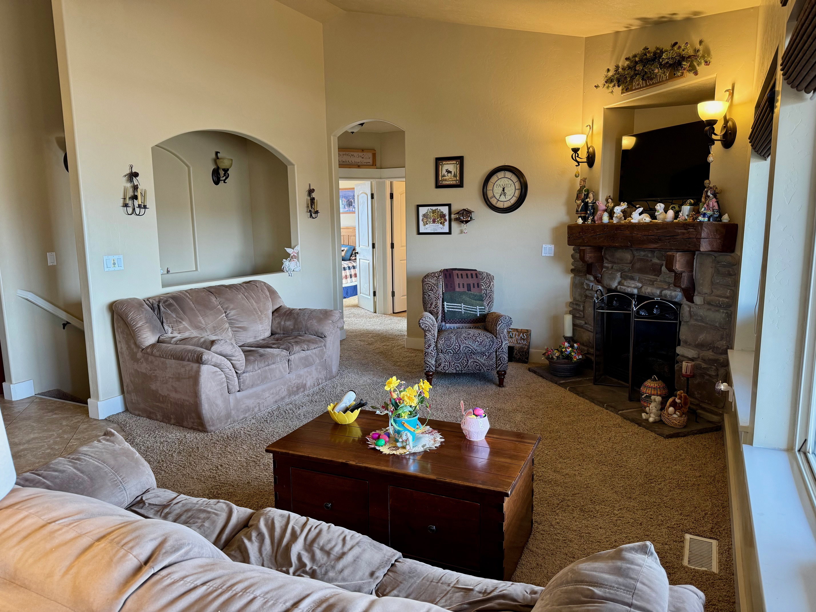Living area featuring carpet flooring, arched walkways, a high ceiling, and a fireplace
