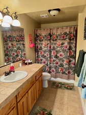 Full bath with vanity, shower / tub combo, a light tile patterned floors