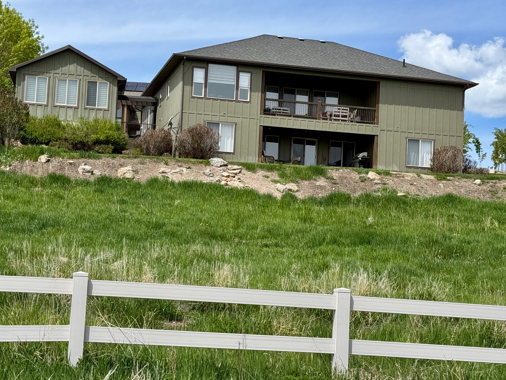 Rear view of house with a balcony and patio on large .56-acre yard