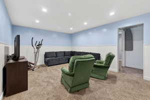 Living room with wainscoting, carpet, and recessed lighting