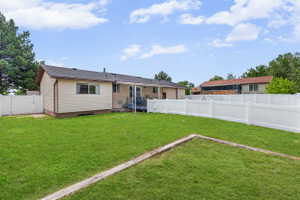 Rear view of house with a fenced backyard and a gate