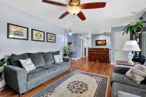 Living area featuring wood finished floors and a ceiling fan