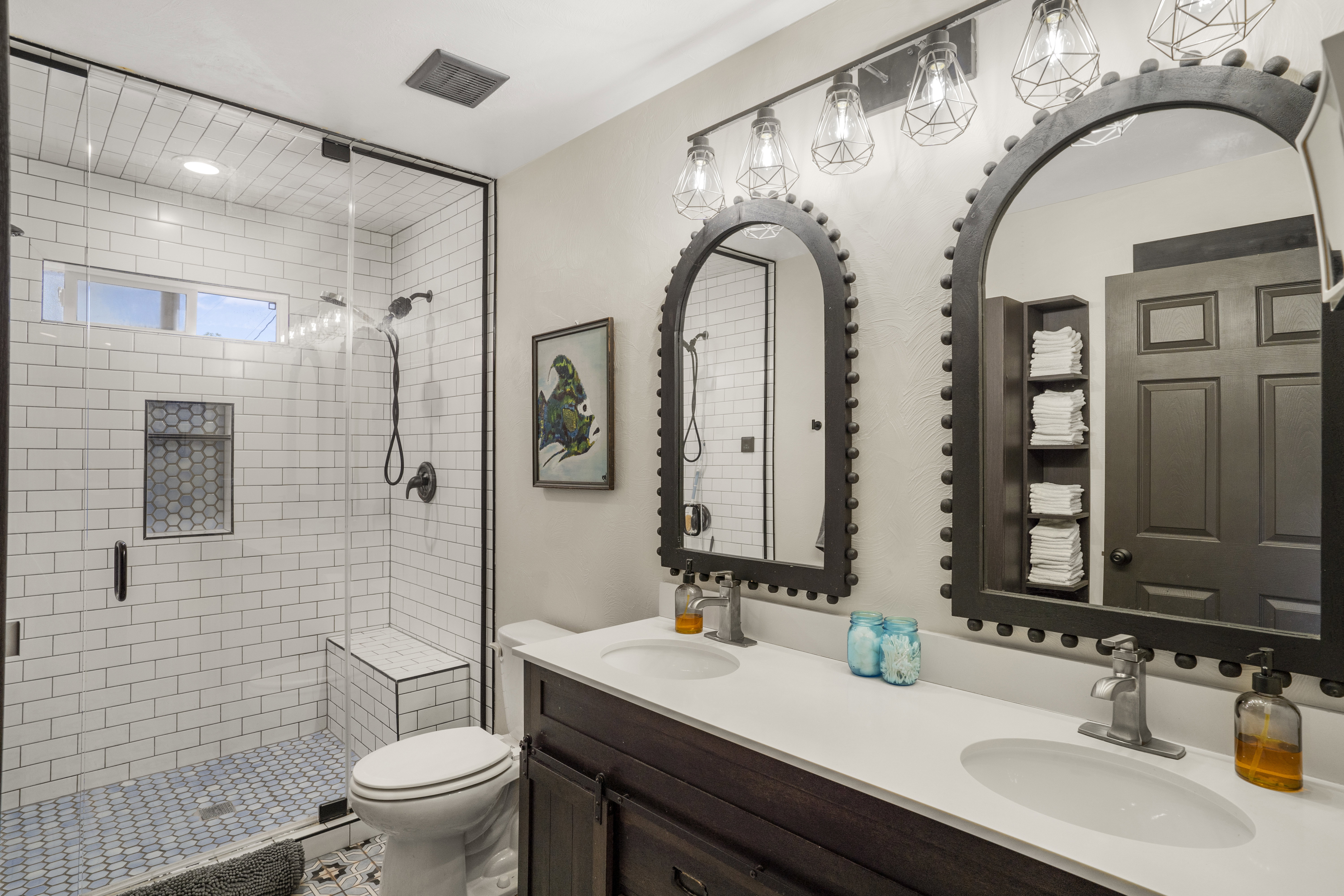 Full bath with double vanity and a stall shower