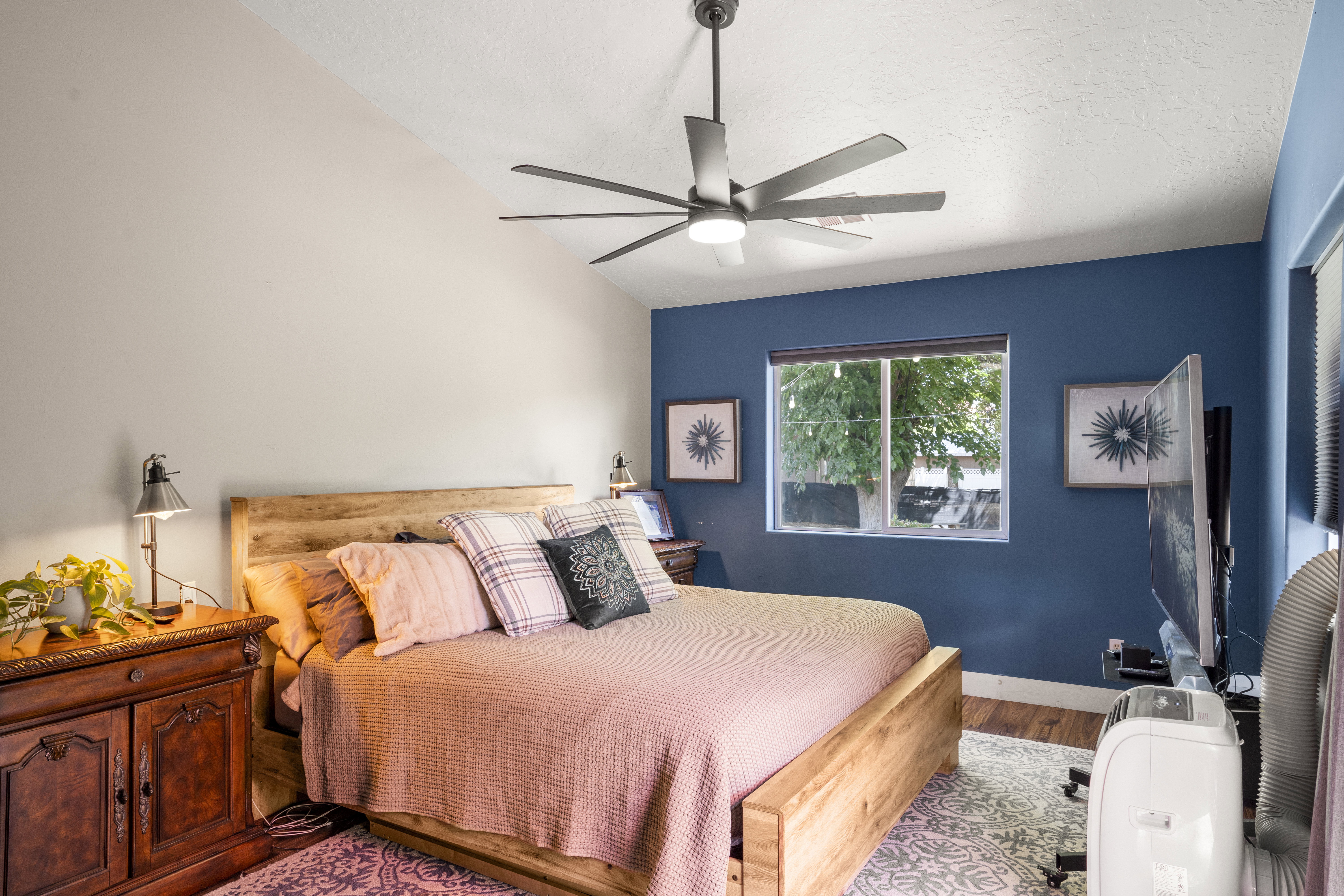 Bedroom with wood finished floors, ceiling fan, and a textured ceiling