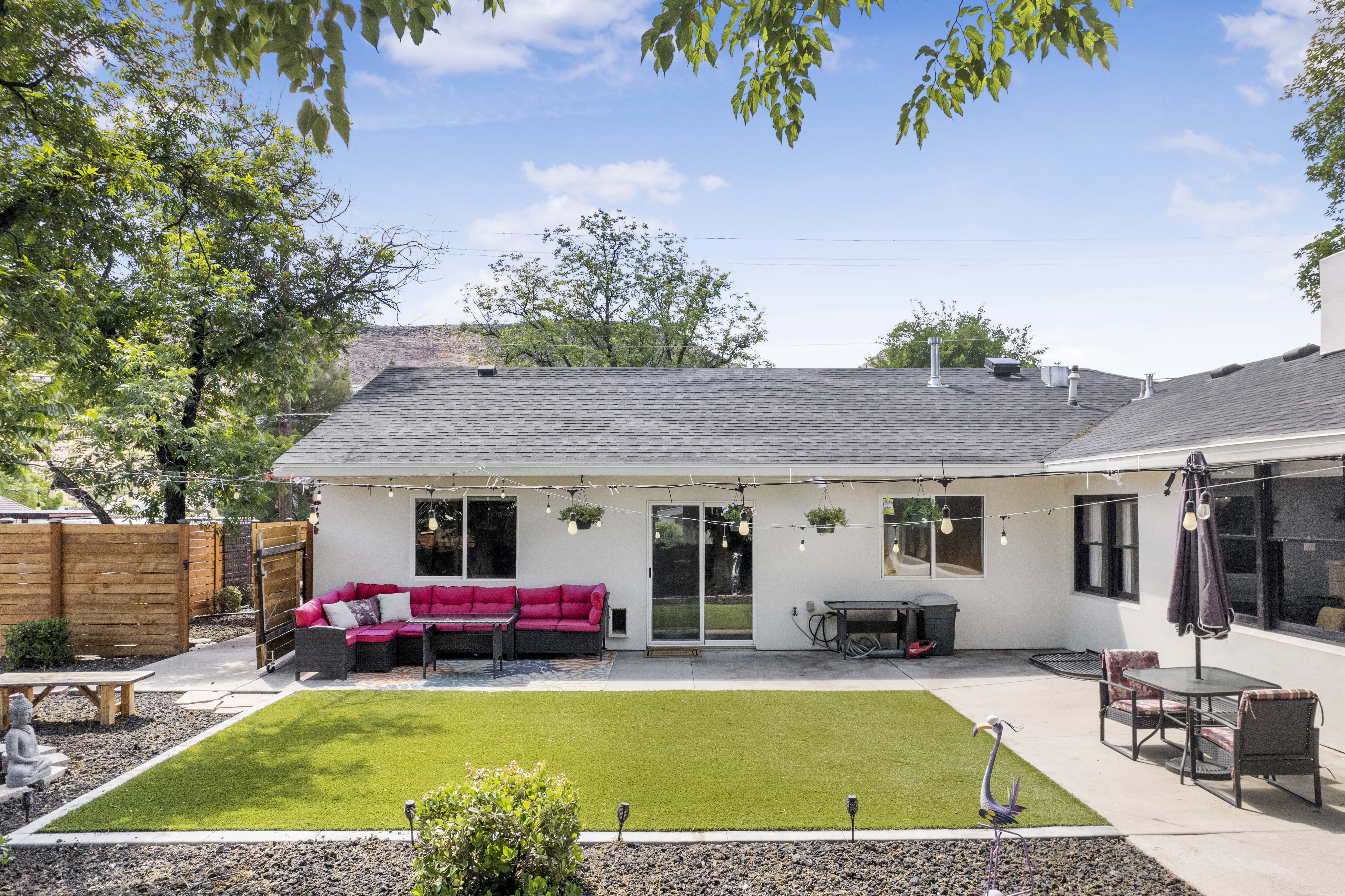 Rear view of property featuring a patio, roof with shingles, an outdoor living space, and stucco siding