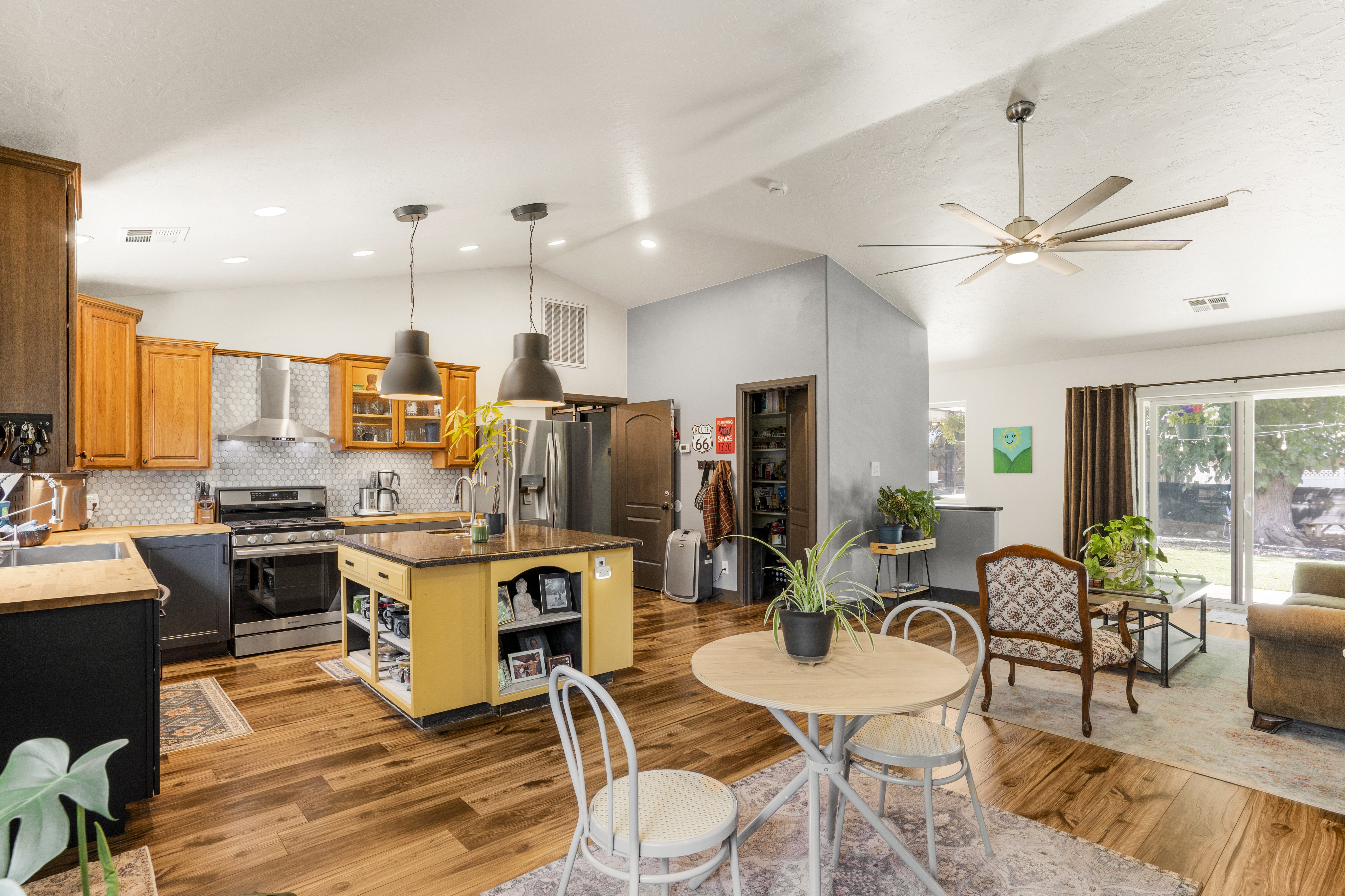 Dual tone kitchen with dual tone cabinets, open shelves, vaulted ceiling, stainless steel appliances, and glass fronted cabinets