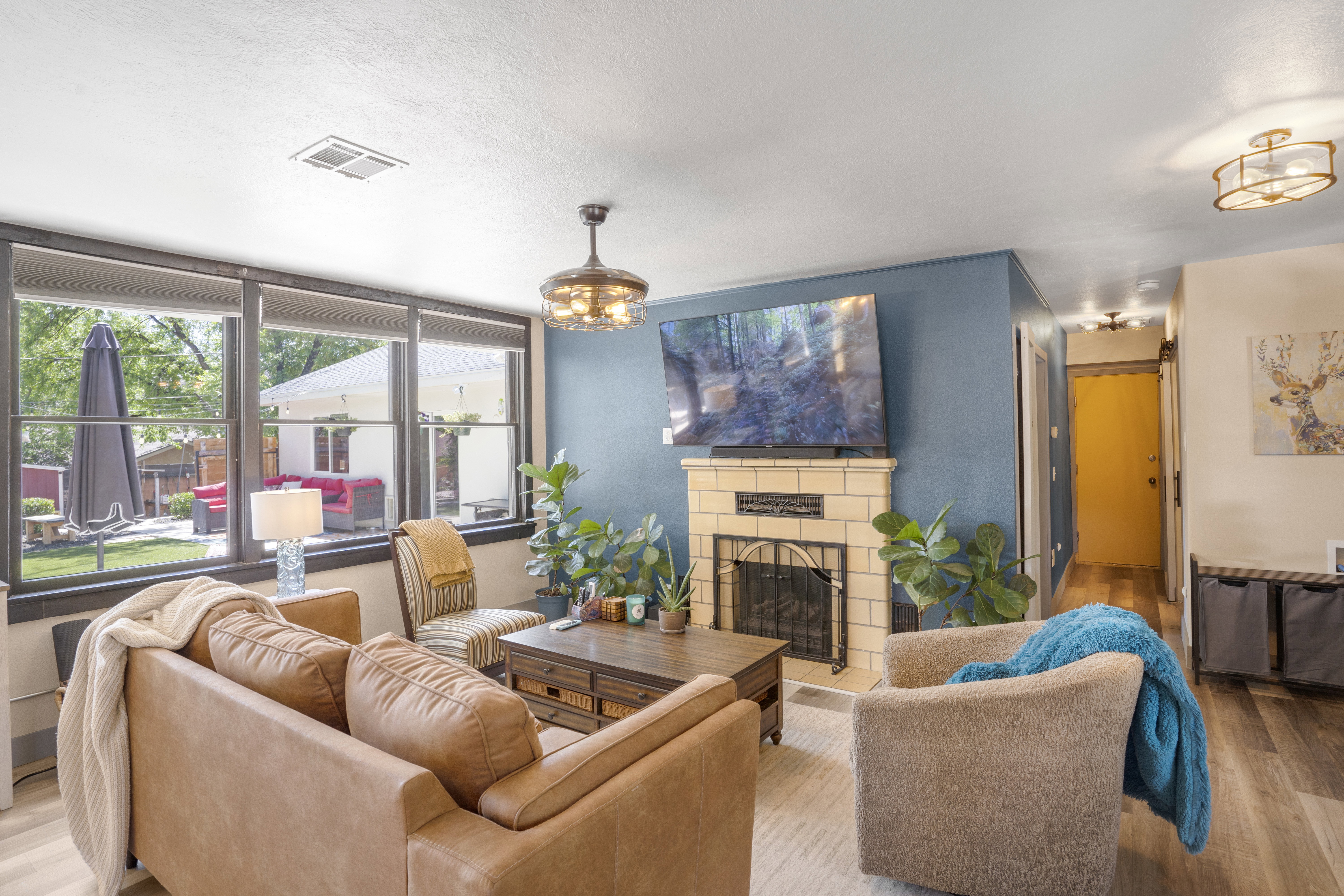 Living room with wood finished floors, a fireplace with raised hearth, a chandelier, and a textured ceiling