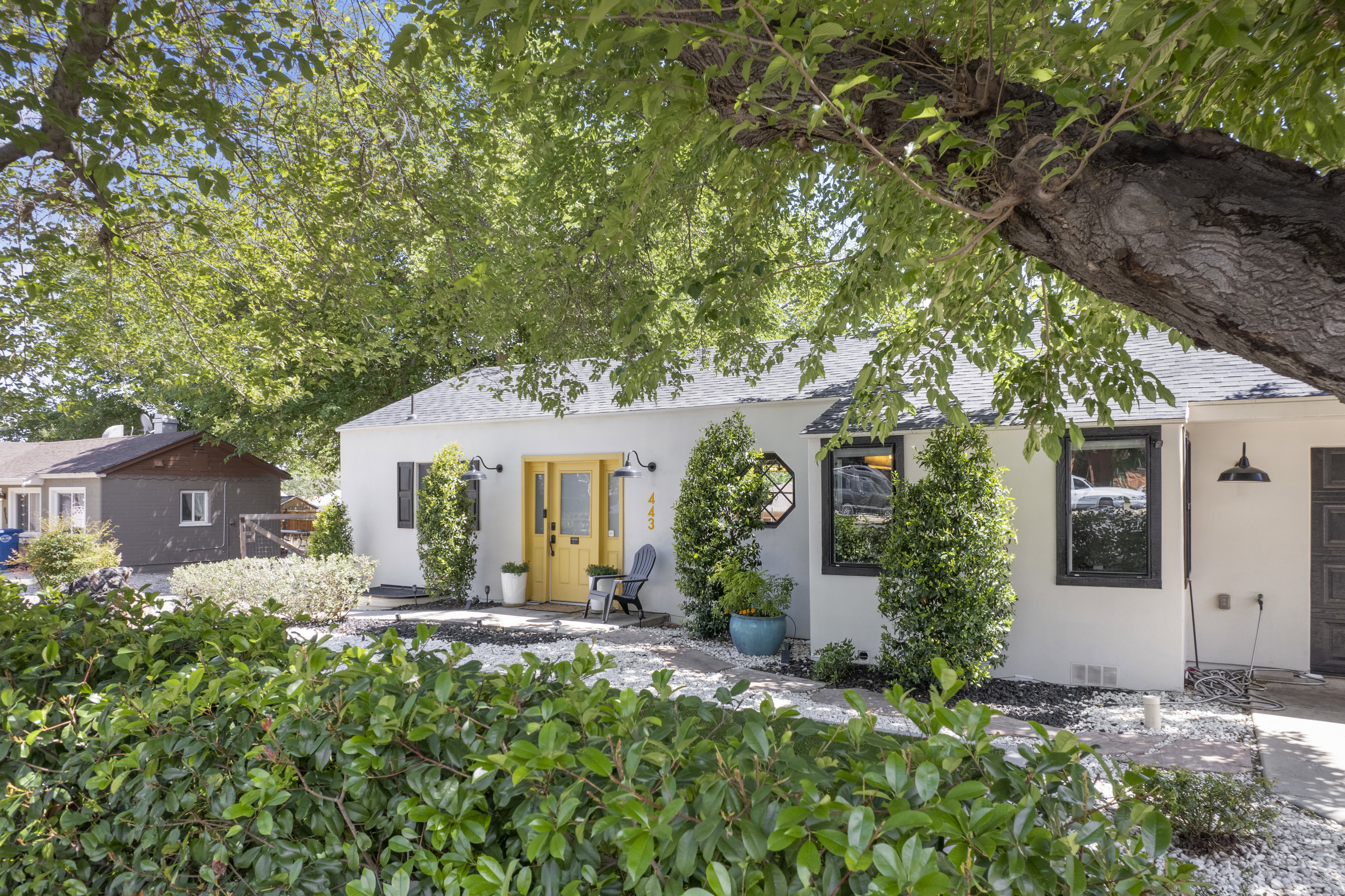Bungalow-style house with roof with shingles, stucco siding, and a patio