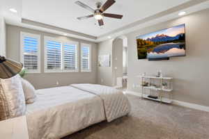 Bedroom with arched walkways, recessed lighting, light carpet, a ceiling fan, and ensuite bath