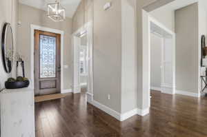 Entryway featuring dark wood-style floors and hanging lights