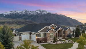 Craftsman house with a gate, a mountain view, concrete driveway, and stone siding