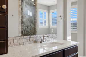 Full bathroom with vanity and a shower stall