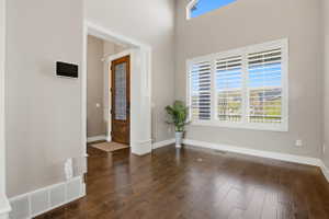 Foyer entrance featuring dark wood-style floors and a high ceiling