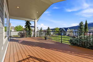 Wooden terrace with a residential view, a mountain view, and a yard
