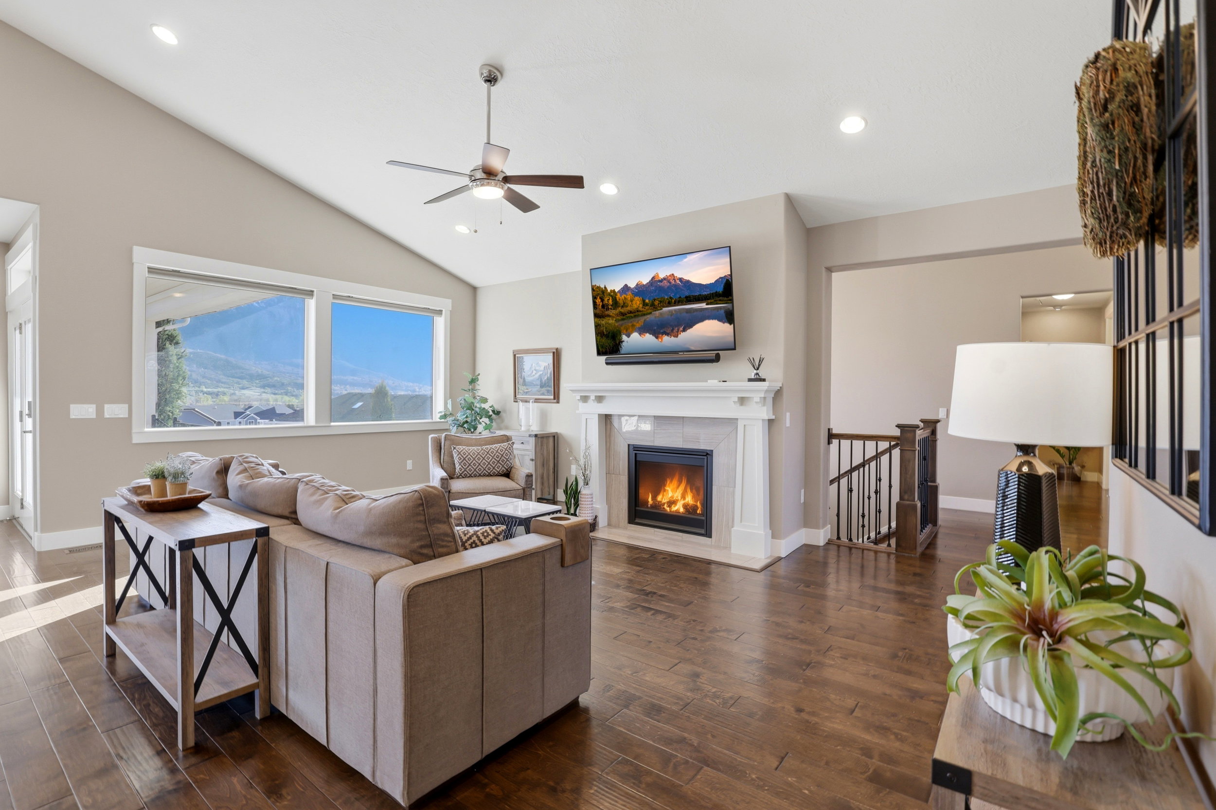 Living room featuring a ceiling fan, dark wood finished floors, a tiled fireplace, lofted ceiling, and recessed lighting