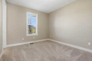 Empty room with light carpet and baseboards