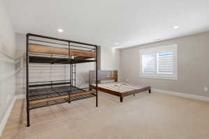 Bedroom with light colored carpet and recessed lighting