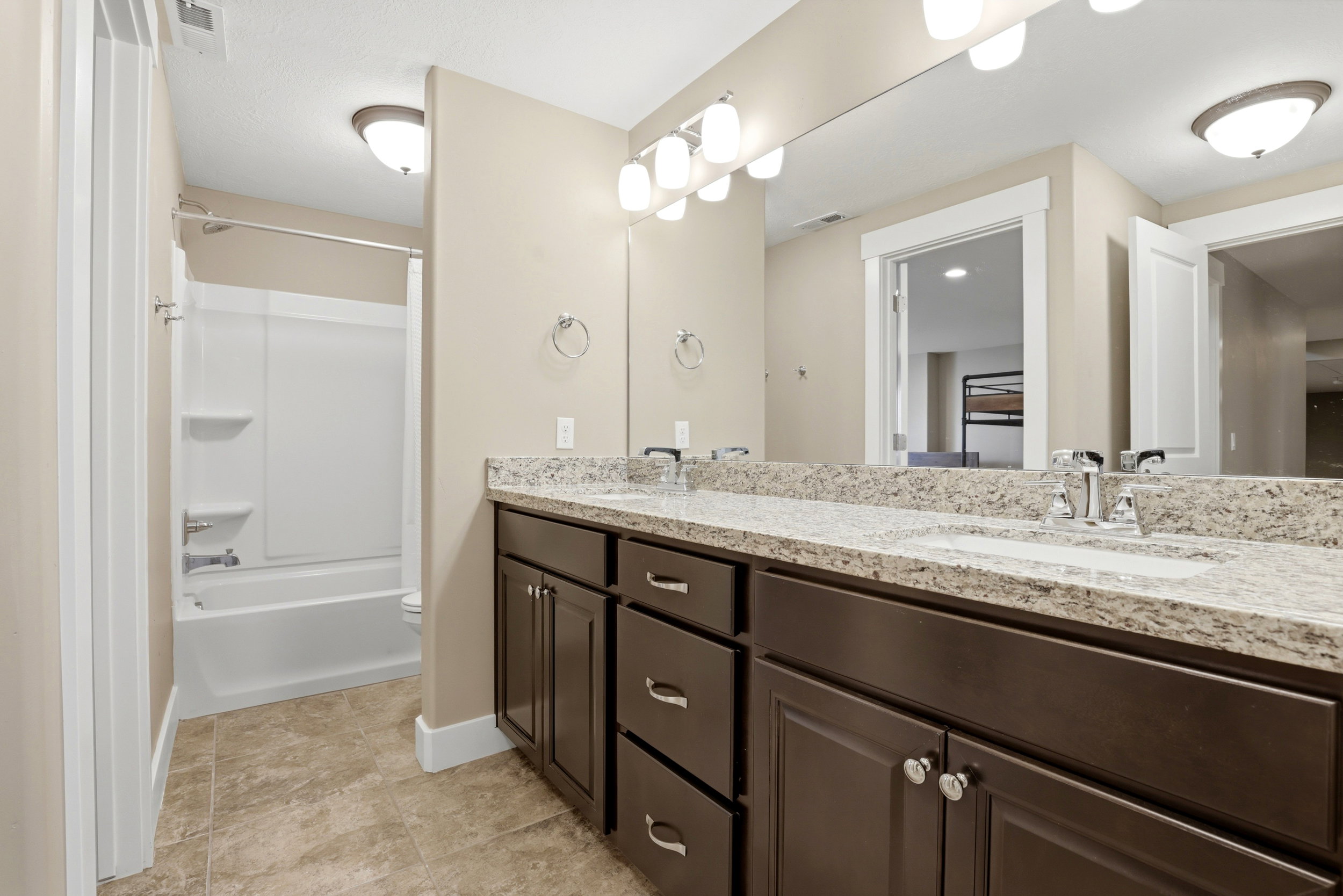 Bathroom featuring double vanity and  shower combination