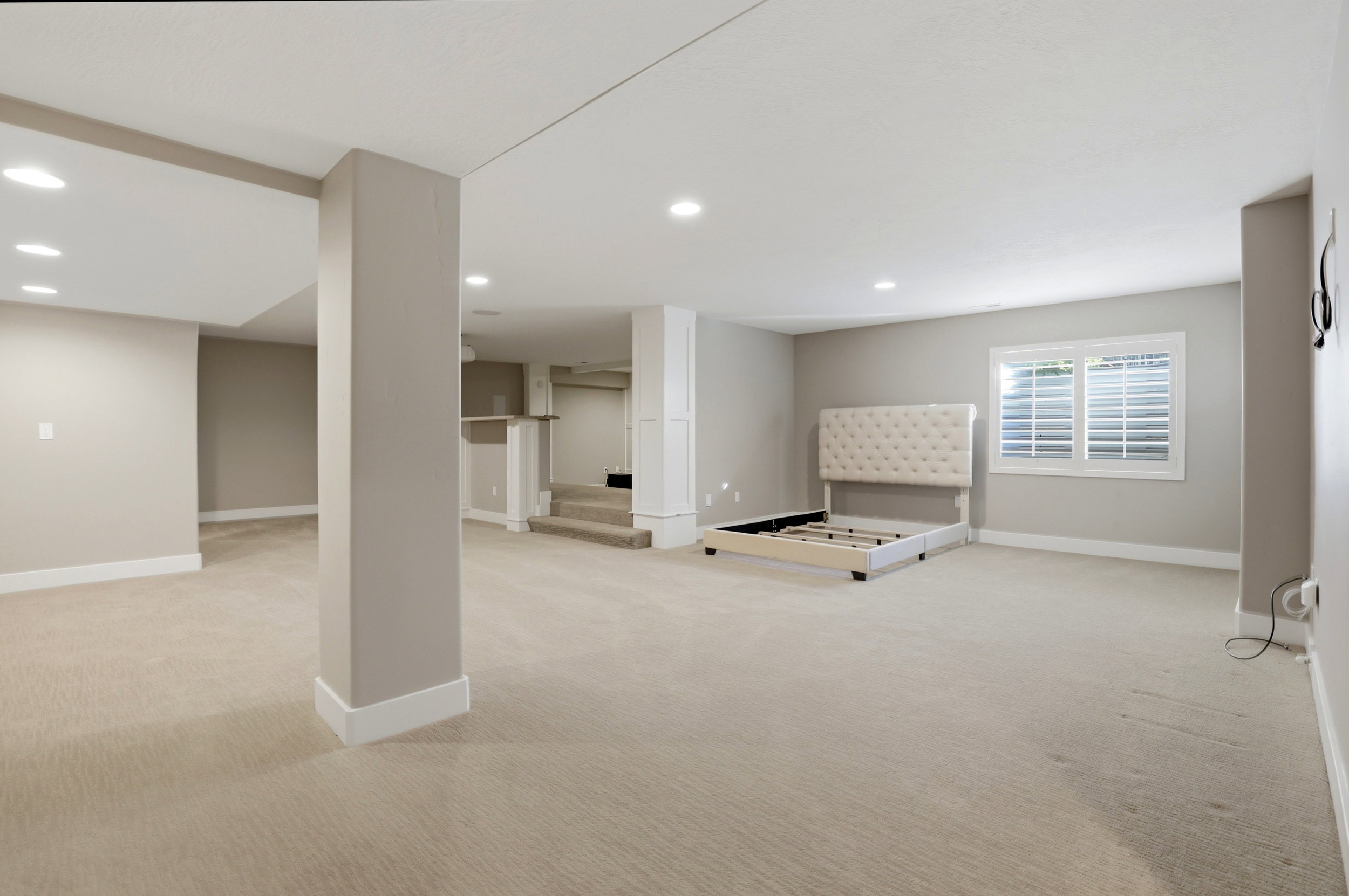 Below grade area with light colored carpet and recessed lighting